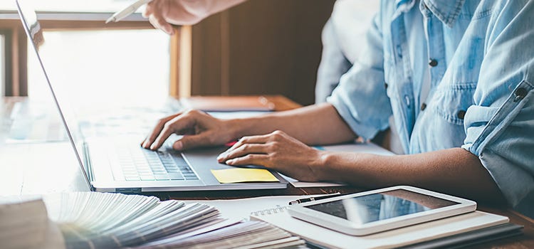 Business owner sitting at a desk using their laptop to create a content marketing strategy