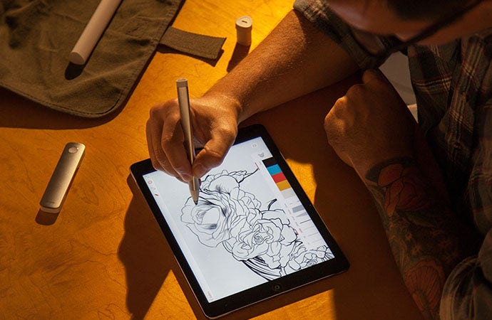 Artist draws a digital sketch of roses on a tablet.