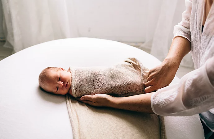 A newborn baby being swaddled