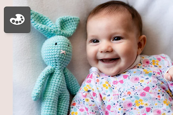 A photo of a newborn baby lying next to a blue stuffed animal.