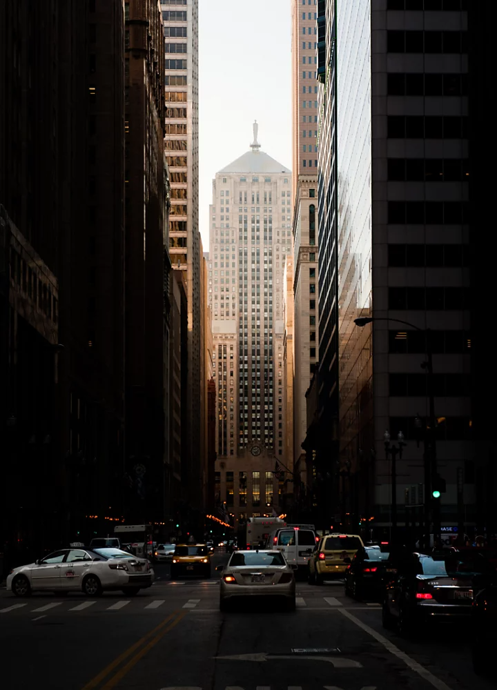 Street-level cityscape photography capturing the darkness created by tall buildings in an urban valley