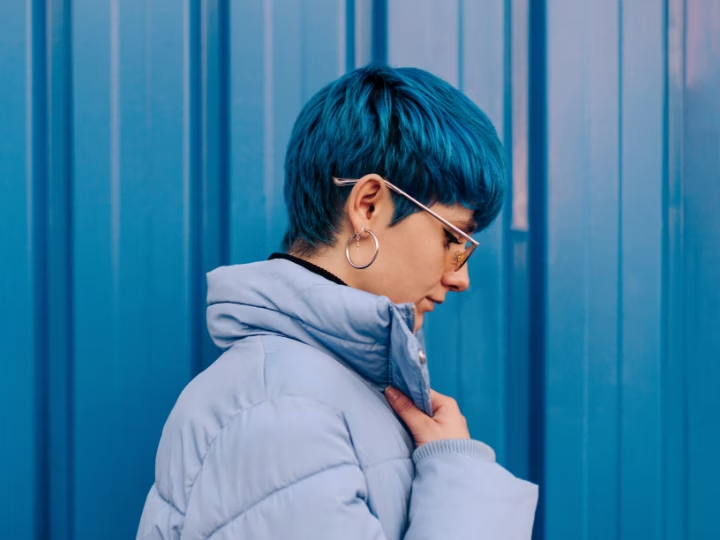 Side view of a person with short, bright blue hair, colorized by changing their hair color in Photoshop.