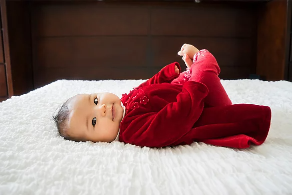 A photo of a newborn baby lying on a bed. The stuffed animal has been removed from the background.