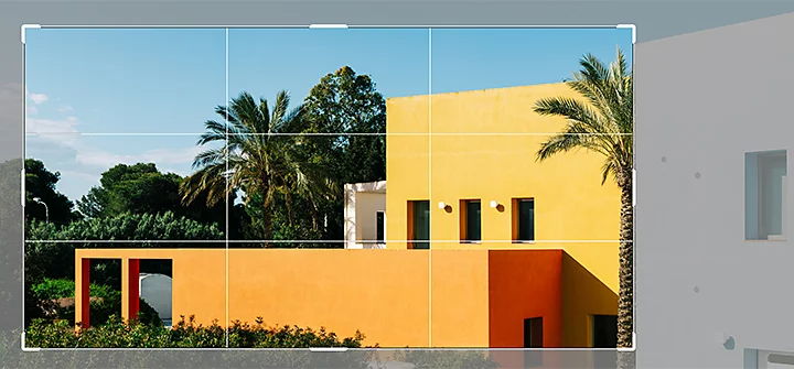 The Adobe Photoshop Crop tool selecting a landscape section of an image of an orange building