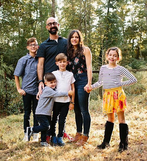 A standing family photo at a park.