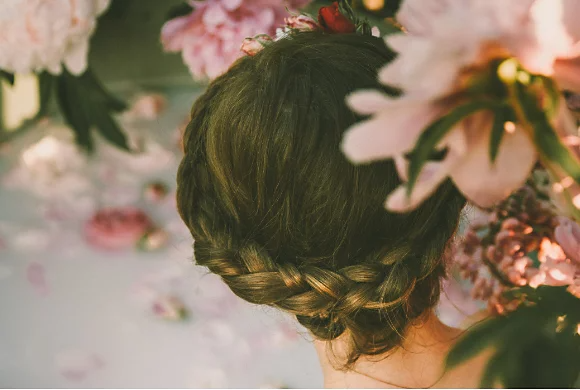 A photo of a person sitting in a milk bath taken from behind their head.