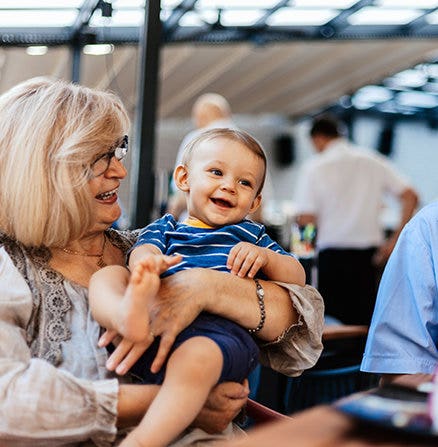 Using focal length to stay focused on the smiling face of a grandmother holding her grandson