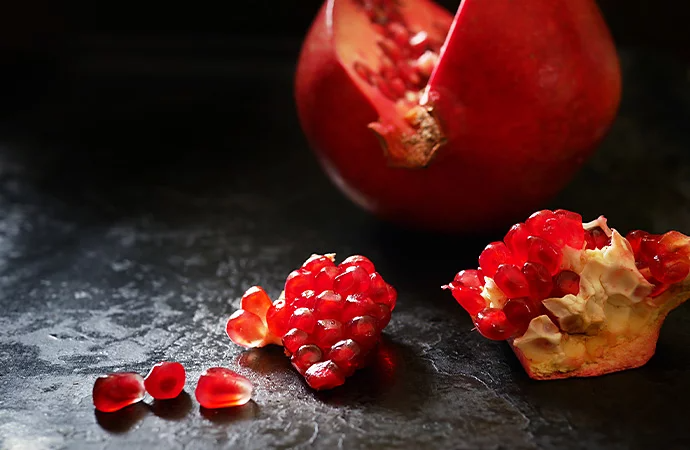 Chunks of pomegranate beautifully photographed on a textured background in an example of high-key lighting