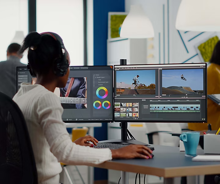 A person video mixing at a desk using multiple computer screens