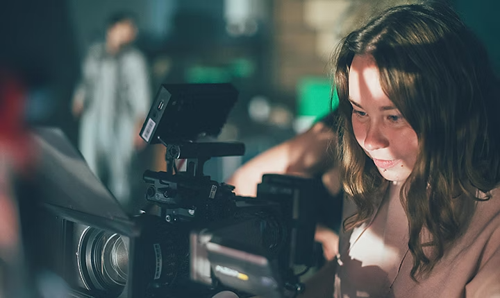 Filmmaker adjusting the setting of a camera