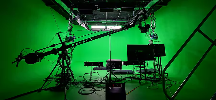 A green screen studio full of film equipment