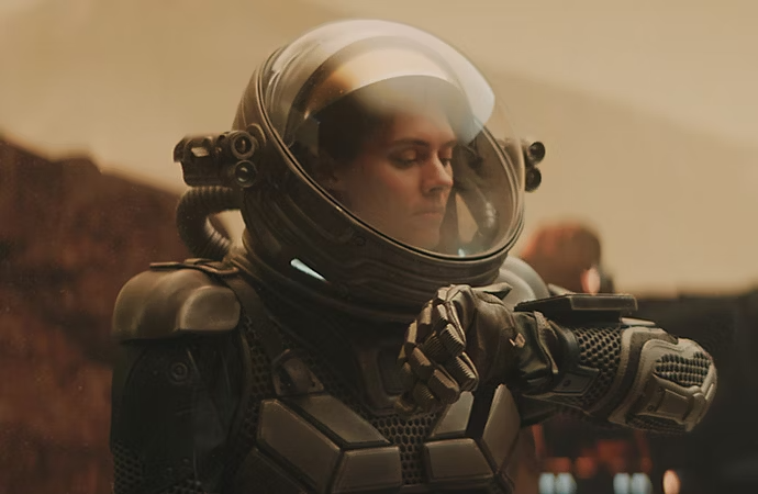 An actor in a spacesuit shown on the surface of a planet with chroma key compositing