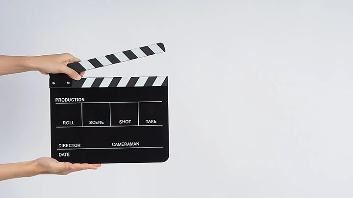 Hands holding an open clapboard.