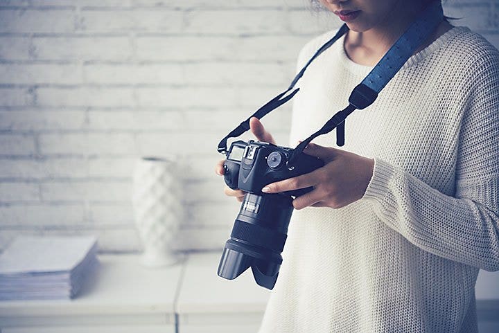 Woman looking at camera hung around her neck.