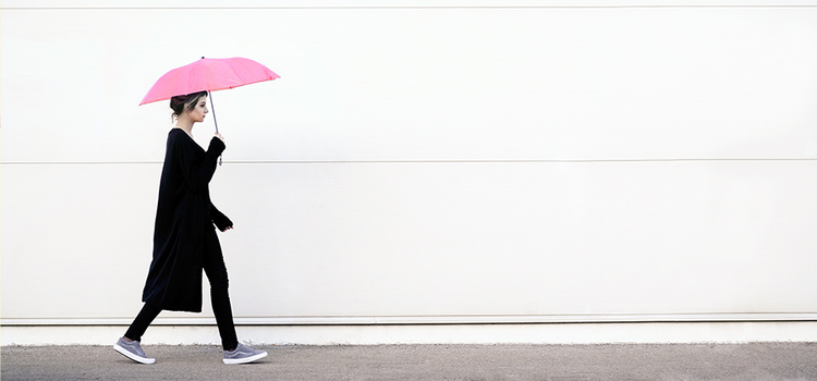 Laufende Frau mit pinkem Regenschirm