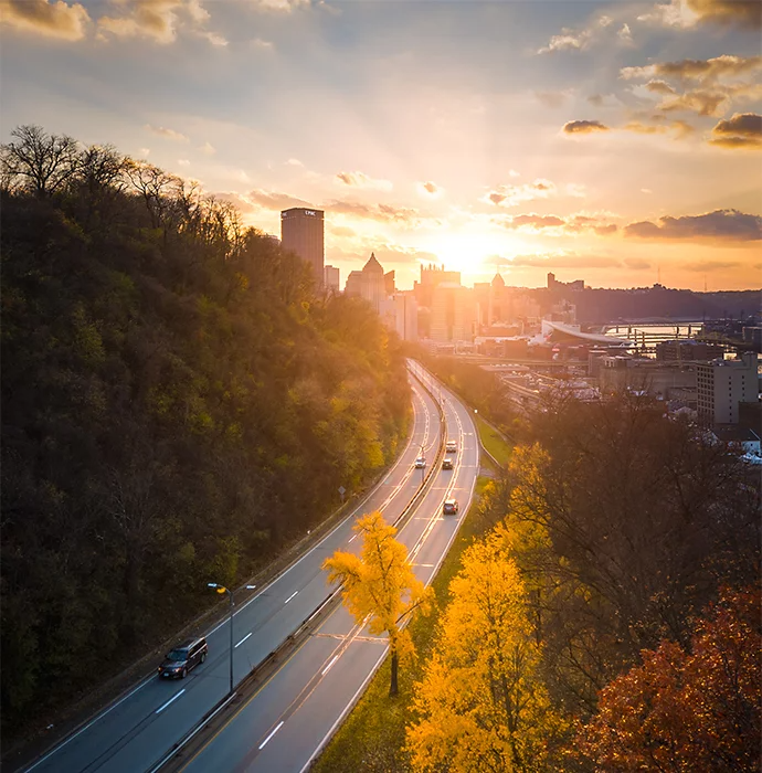 A highway running through a forest heading toward a city in the background