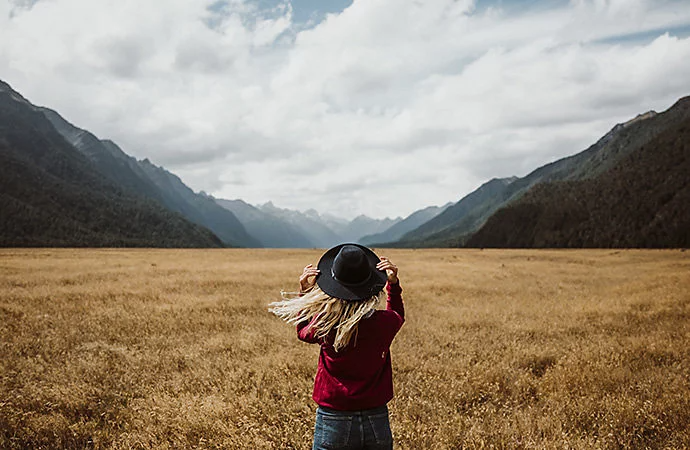 Young person in field with the wind blowing through their hair