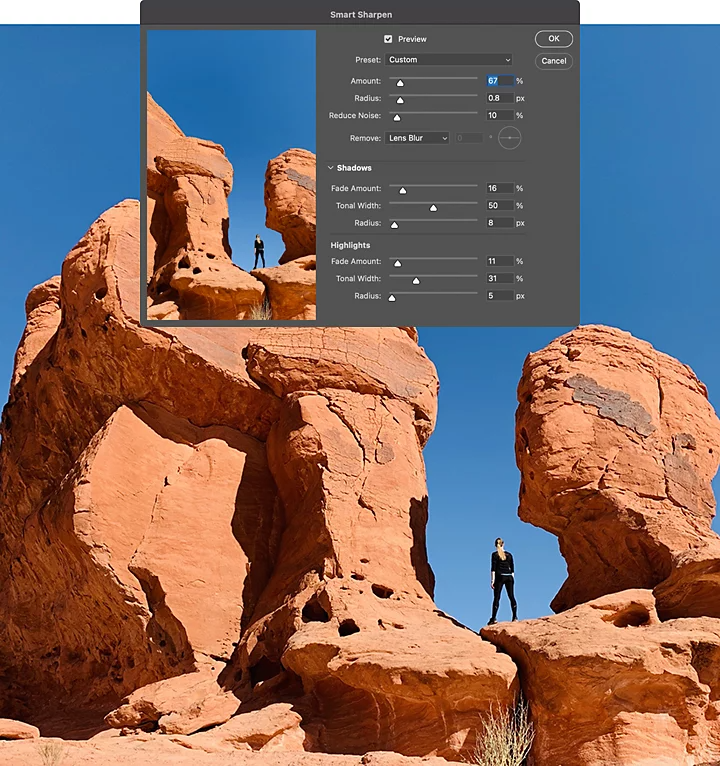 A person standing in between two rock formations with the Adobe Photoshop Smart Sharpen tool superimposed over it