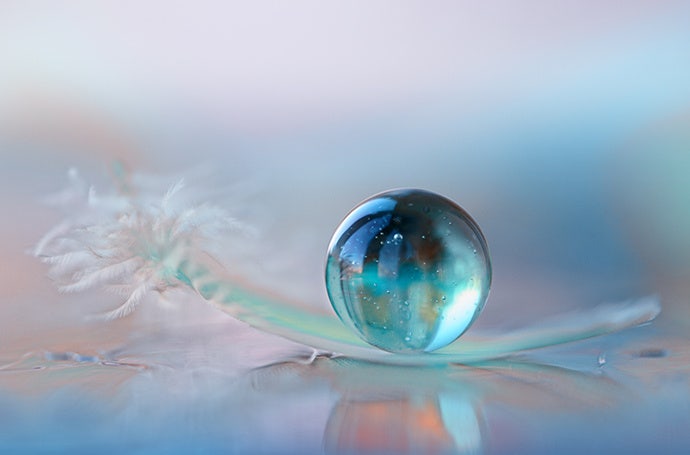 Marble on top of a feather shot as still-life image