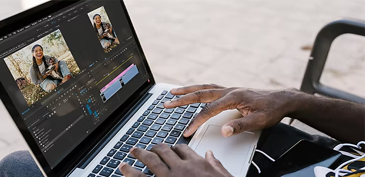 Eine Person, die ein Video in Adobe Premiere Pro auf ihrem Laptop bearbeitet