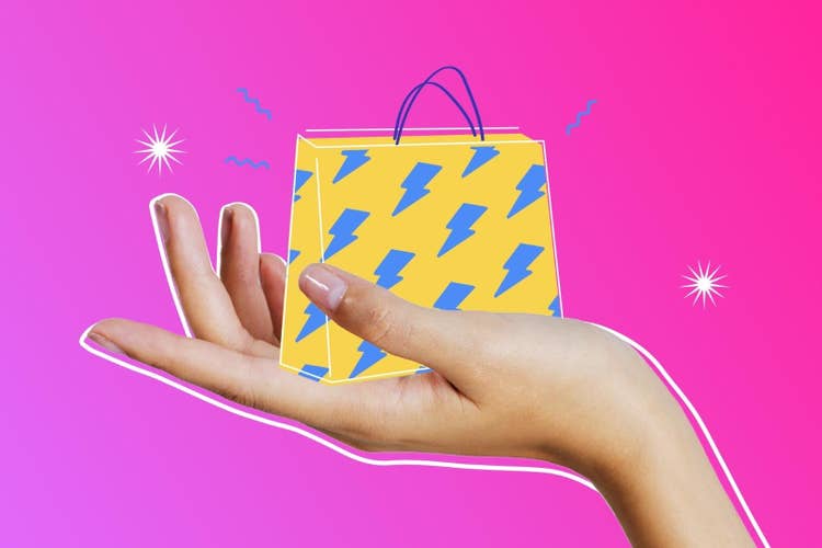 Eine ausgestreckte Hand mit der Grafik einer Etsy-Einkaufstasche vor einem pinkfarbenen Hintergrund