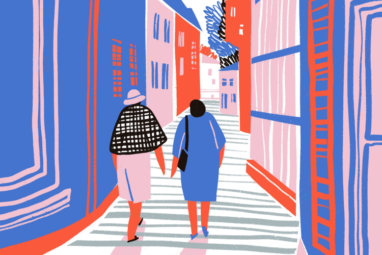 Zwei Frauen gehen eine Straße entlang Automatisch generierte Beschreibung