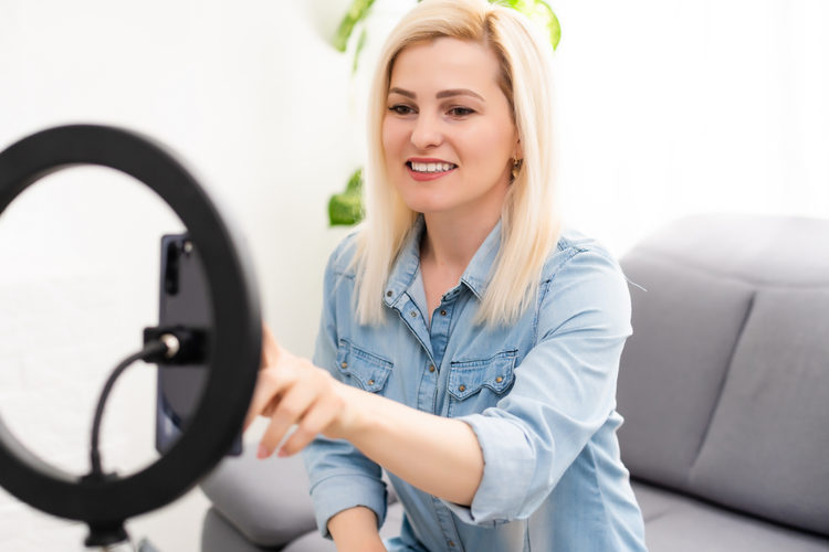 A person smiling while holding a circular object Description automatically generated