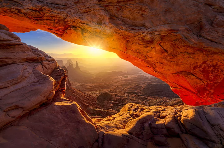 A photo of a sunset on a desert landscape.