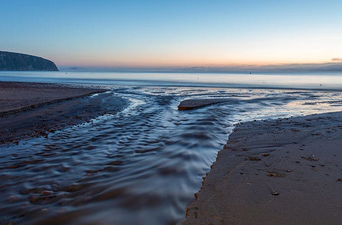 Water flowing into the ocean captured at a slow shutter speed