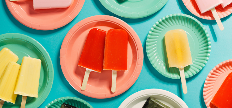 Color photo of plates with popsicles on them that are neatly arranged on a table