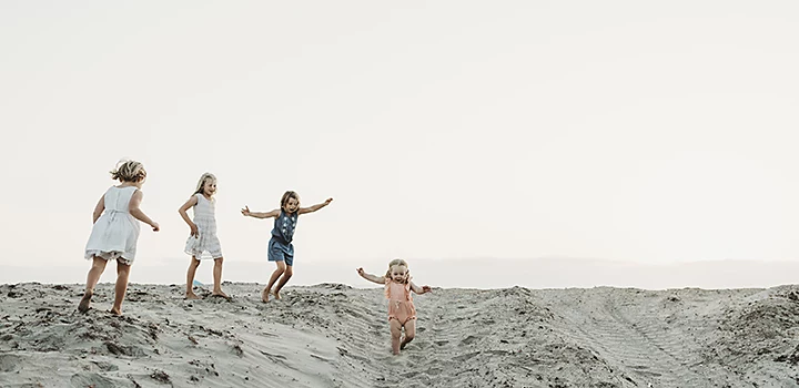 Cuatro niños siendo ellos mismos en la playa para una foto