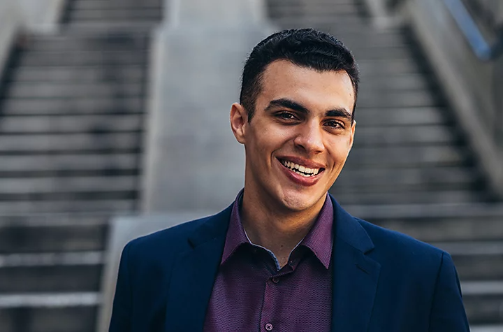 A person posing in front of outdoor staircases for a corporate headshot photo