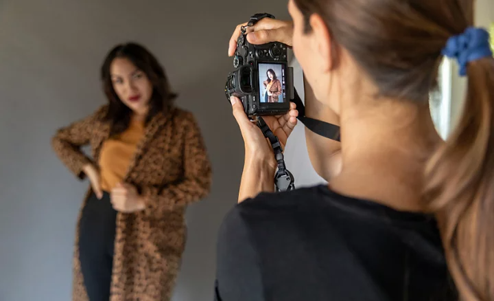 A candid photo of a photographer shooting a portrait of a fashion model.