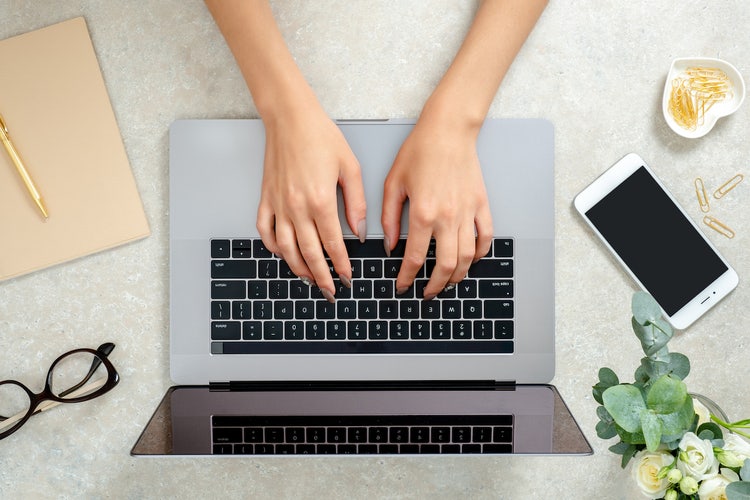 Content creator: aerial view of a person typing on their laptop