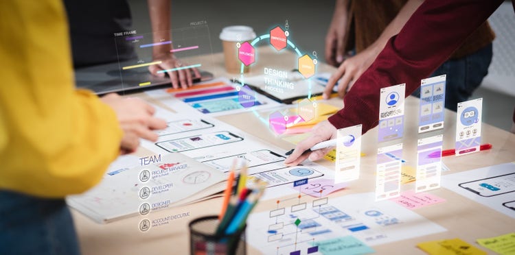 A team working together to create a marketing plan by laying out different parts of their work on a table