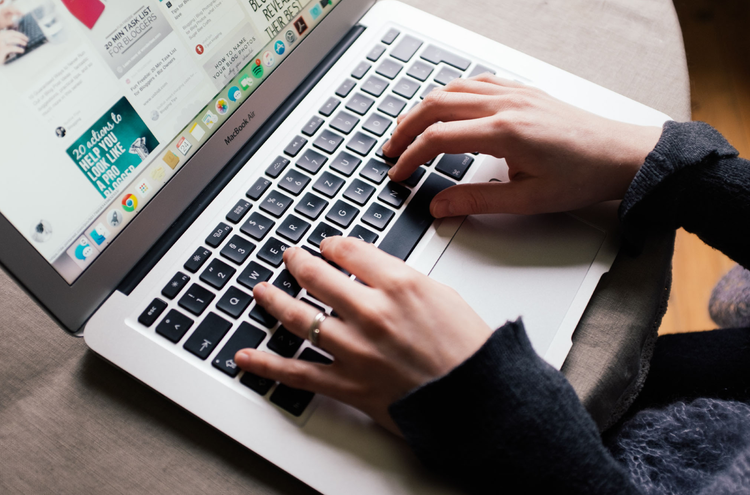 Laptop Hands touch the keys of a laptop keyboard. The screen of the laptop shows Pinterest.