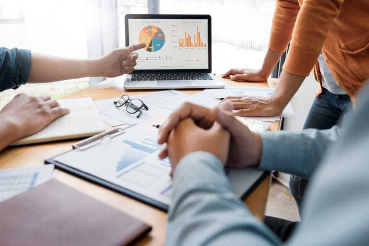 A person presenting their proposed marketing plan to their team using a laptop presentation