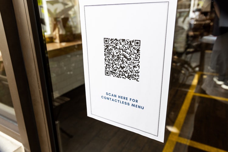 Photograph featuring a poster of a QR code attached to a window