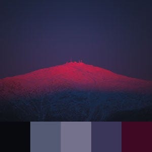 A color palette created from an image of a distant mountain with a pink-purple sunset reflecting off of it with a dark sky in the background