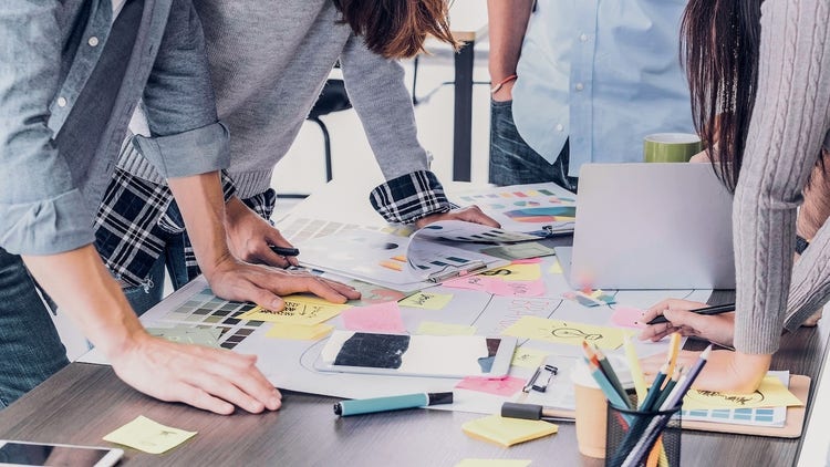 Brand strategy: A team standing around a table looking over papers