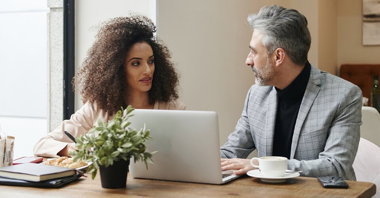 Two LLC business owners reviewing an operating agreement together at a table