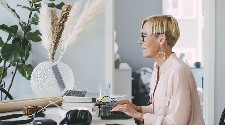 A business owner at their desk creating a confidentiality agreement on their laptop