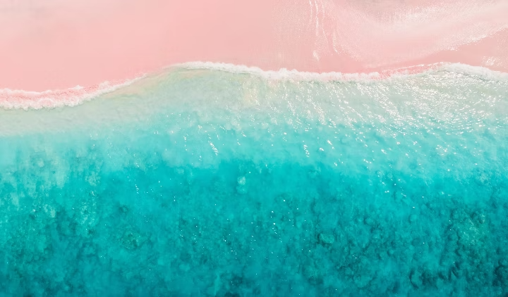 Plage tropicale vue de haut avec sable rose et océan turquoise