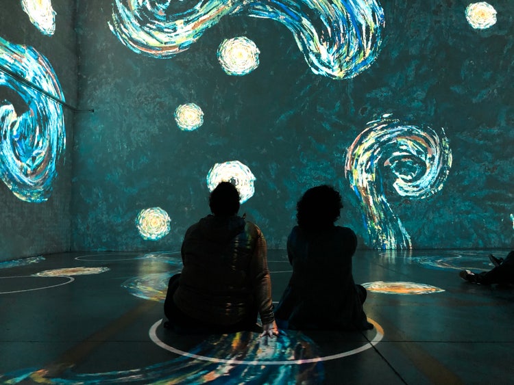 Deux personnes se tiennent au cœur d’une œuvre d’art interactive sur Van Gogh.