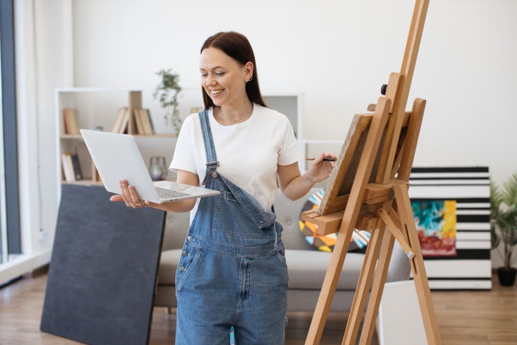 Artiste peintre avec un ordinateur à la main