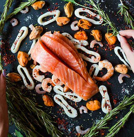 Artistic food photograph of sliced raw fish and other seafood