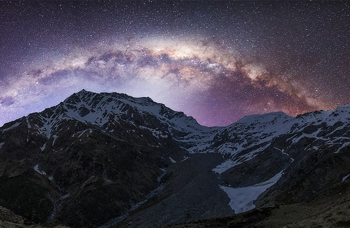 Montagnes enneigées avec un ciel nocturne étoilé en arrière-plan