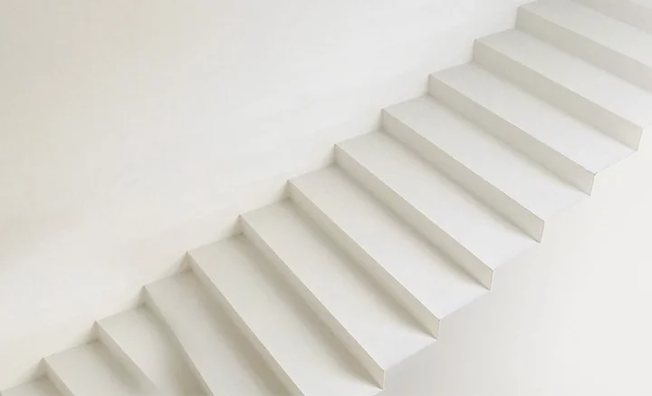 Marches d’un escalier blanc devant un mur blanc