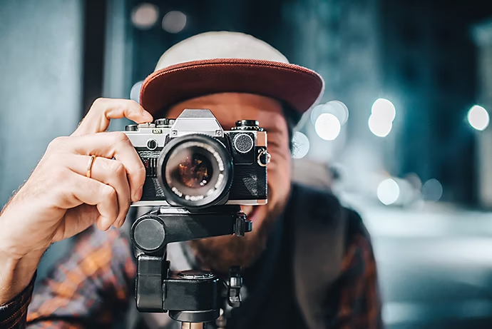 Homme prenant une photo avec un appareil argentique