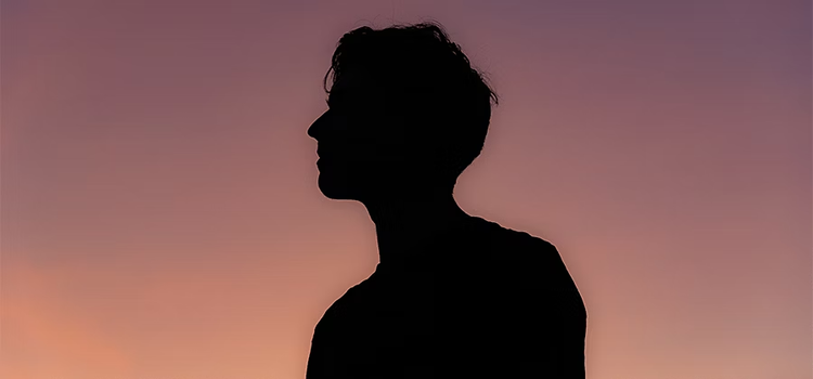 Silhouette d'une personne devant un coucher de soleil